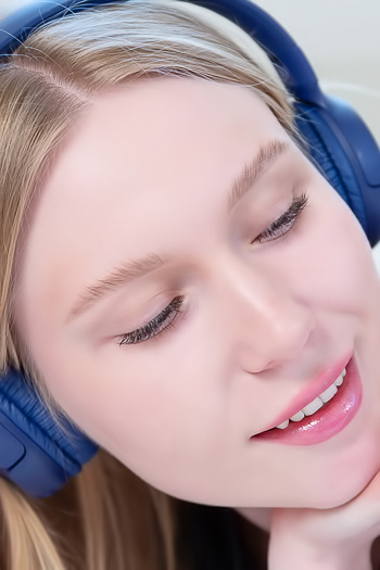 Monique Samson curls up in bed listening intently with sparking eyes